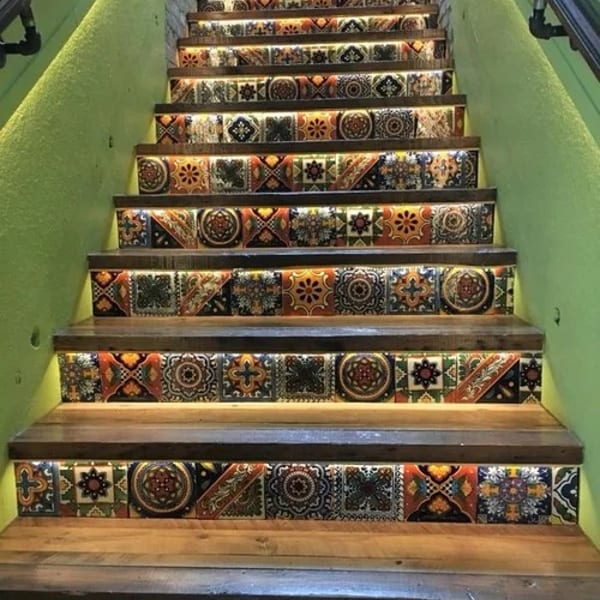 Ornate staircase with vibrant patterned tiles, wooden treads, and subtle under-step lighting.