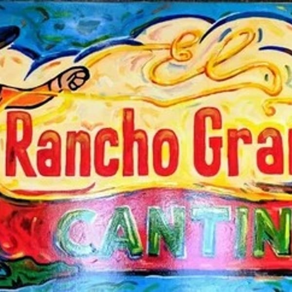 Colorful El Rancho Grande Cantina sign with a mariachi man and a cactus.