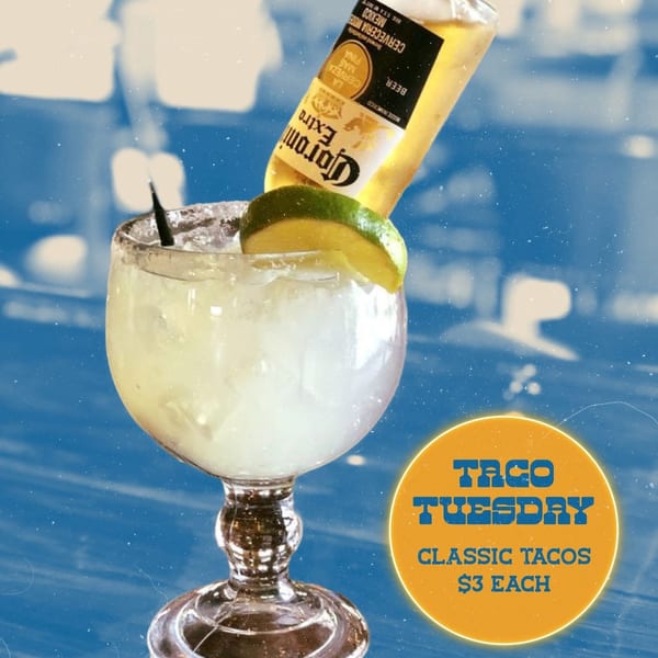 Corona beer bottle upside down in a margarita glass with a lime wedge, advertising Taco Tuesday.