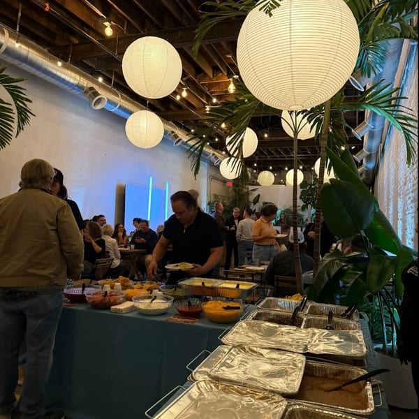 Guests enjoying a buffet meal in a festive room with paper lanterns and plants.
